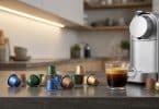 Machine à café moderne avec des capsules de différentes couleurs et une tasse de café fumant sur un comptoir de cuisine.