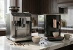 Deux machines à café Jura haut de gamme posées sur un plan de travail en marbre avec des tasses de café.