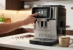 Une personne sélectionne un café sur l'écran tactile d'une machine à grain moderne dans une cuisine lumineuse.