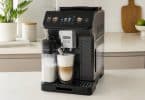 Machine à café à grain De'Longhi Eletta Explore préparant un latte macchiato dans une cuisine moderne.