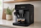 Machine à café expresso automatique De'Longhi noire préparant deux cafés sur un plan de travail dans une cuisine moderne.