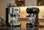 Deux machines à café Smeg sur un plan de travail de cuisine, l'une automatique et l'autre manuelle, dégageant de la vapeur.