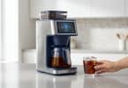 Machine à café moderne avec écran tactile préparant un cold brew dans une cuisine lumineuse.