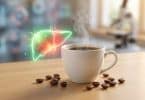 Une tasse de café fumante sur une table en bois avec une illustration holographique d'un foie humain en arrière-plan.