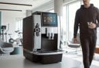 Machine à café expresso professionnelle posée sur un comptoir dans un espace de détente de salle de sport.
