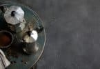 Vue de dessus de deux cafetières italiennes, l'une en aluminium et l'autre en inox, posées sur une table en bois.