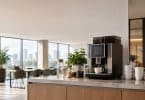 Machine à café moderne dans une cuisine de bureau avec vue sur la ville.
