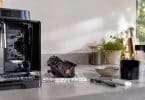 Groupe café amovible d'une machine DeLonghi posé sur un torchon à côté d'une brosse de nettoyage et d'un tube de graisse.