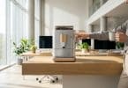Une femme utilise une machine à café automatique moderne dans un bureau lumineux et épuré.